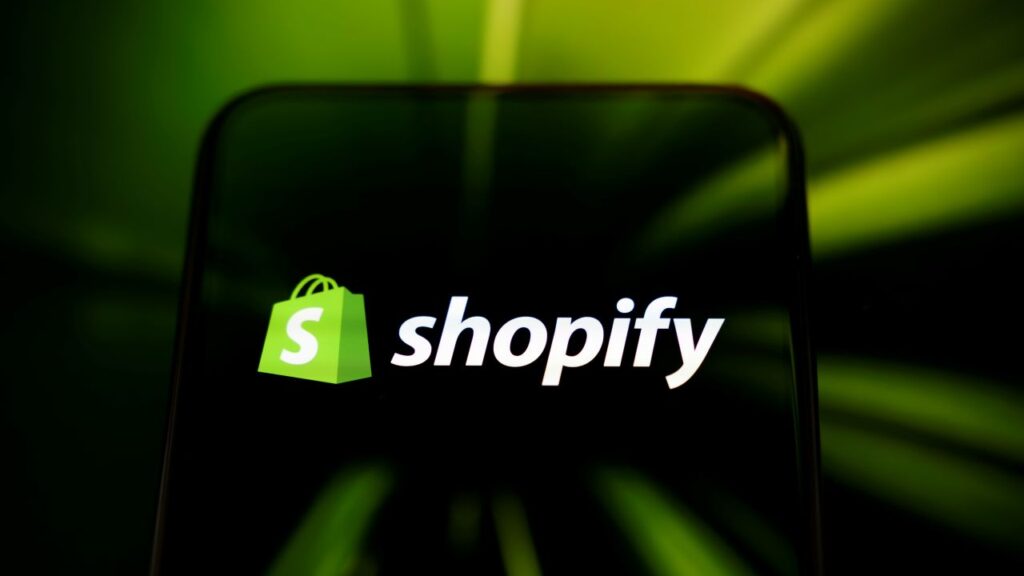 Image of the Shopify logo which consists of a dollar sign in white on a green shopping bag against a black background
