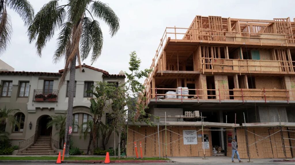 Image of an apartment complex being built adjacent to a stately old home in Santa Monica