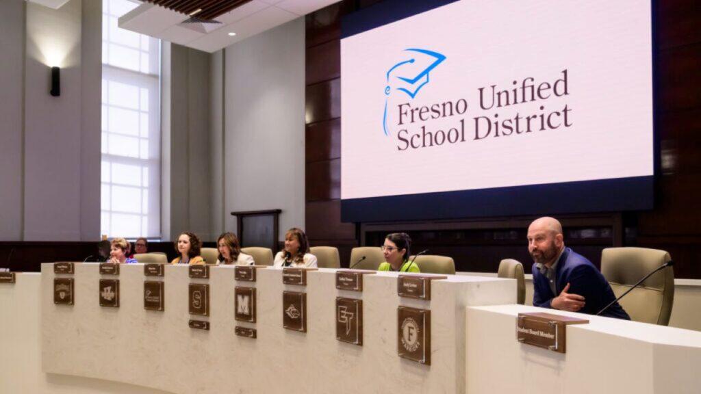 Panoramic view of Fresno Unified trustees listening to a presentation at their meeting.