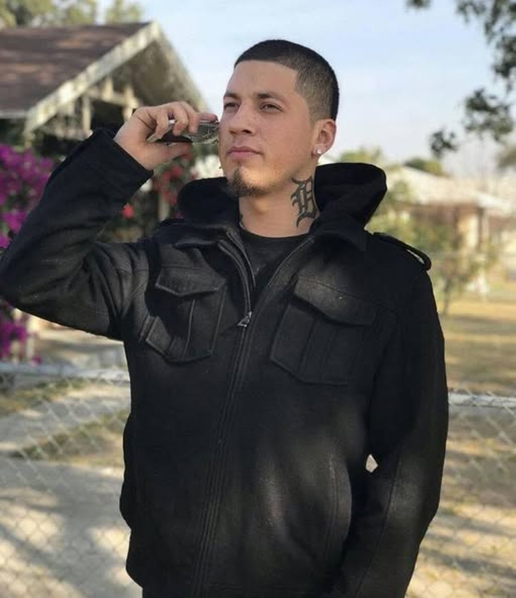 Image of Daniel Ramirez facing toward a camera and holding a cell phone to his ear