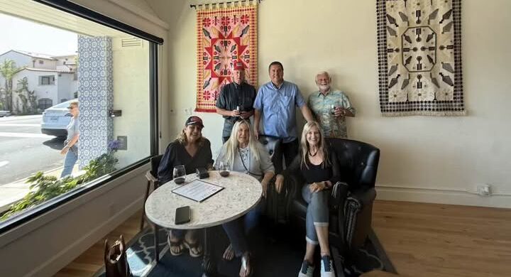 Image of people in the corner of a wine tasting room posting for a picture