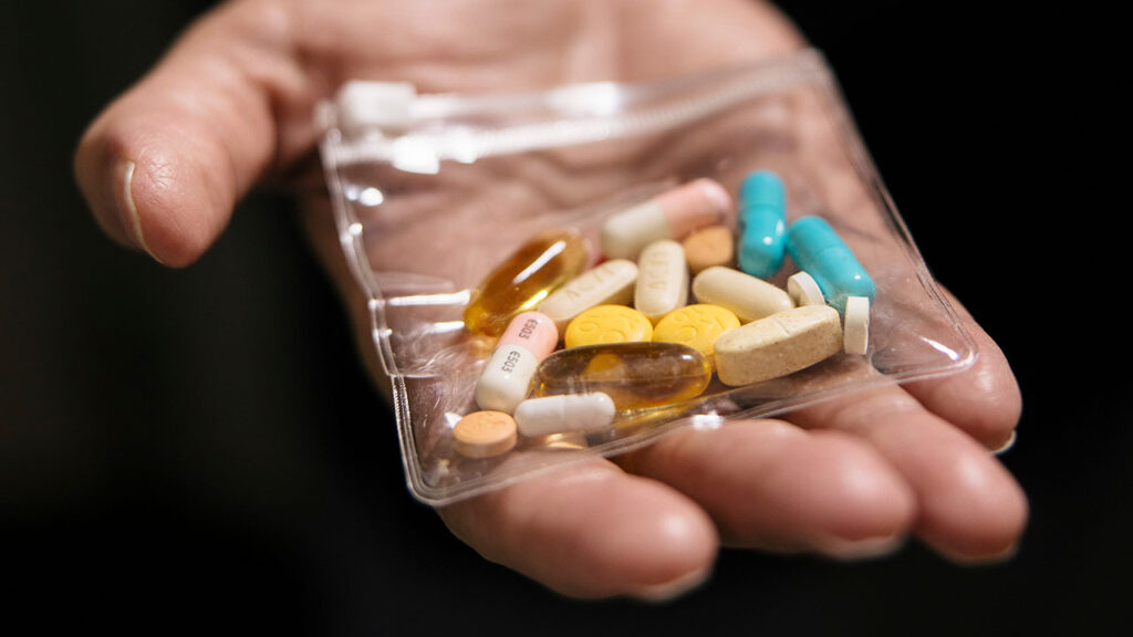 Tracy Atteberry, who has chronic granulomatous disease, a rare inherited immune disorder, displays a package of the pills he must take daily, at the National Institutes of Health in Bethesda, Md., Sept. 4, 2025. Gene therapies for rare diseases are frequently developed then discarded by drug companies because they cannot afford to produce the treatment for more patients. (Alyssa Schukar/The New York Times)