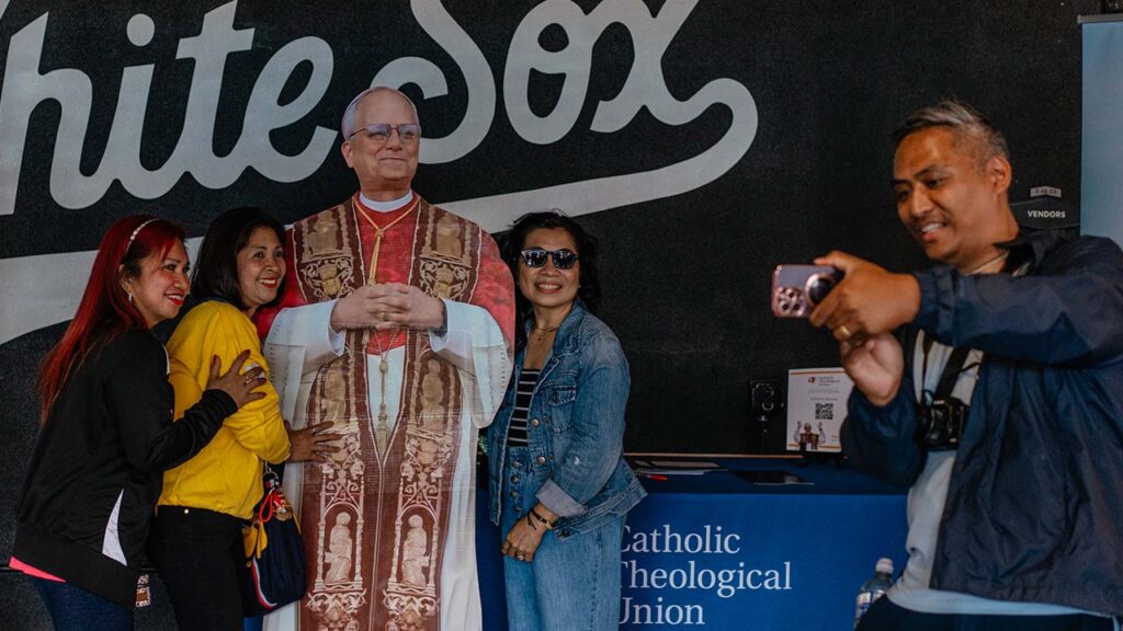 Fans pose with a cutout of Pope Leo XIV, at a public Mass at Rate Field on Chicago’s South Side, on June 14, 2025. The elevation to the papacy of a Chicago native and lifelong supporter of the White Sox has been a godsend for a team that had been failing on the field and with fans. (Jamie Kelter Davis/The New York Times)