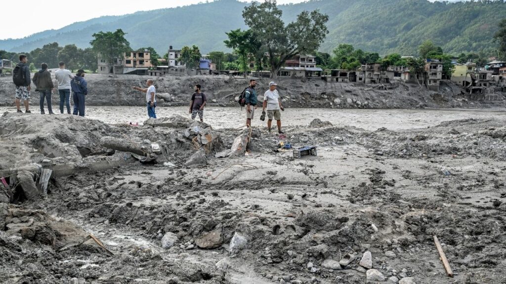 A swollen river near flood-damaged buildings in Devighat, Nepal, after floods caused by a glacier breaking in the Himalayas, Aug. 28, 2026. Putting the cost of recovery at $5 billion, a senior Nepali official said his country had requested urgent financial help from the United Nations’ special fund for climate-disaster recovery. (Atul Loke/The New York Times)
