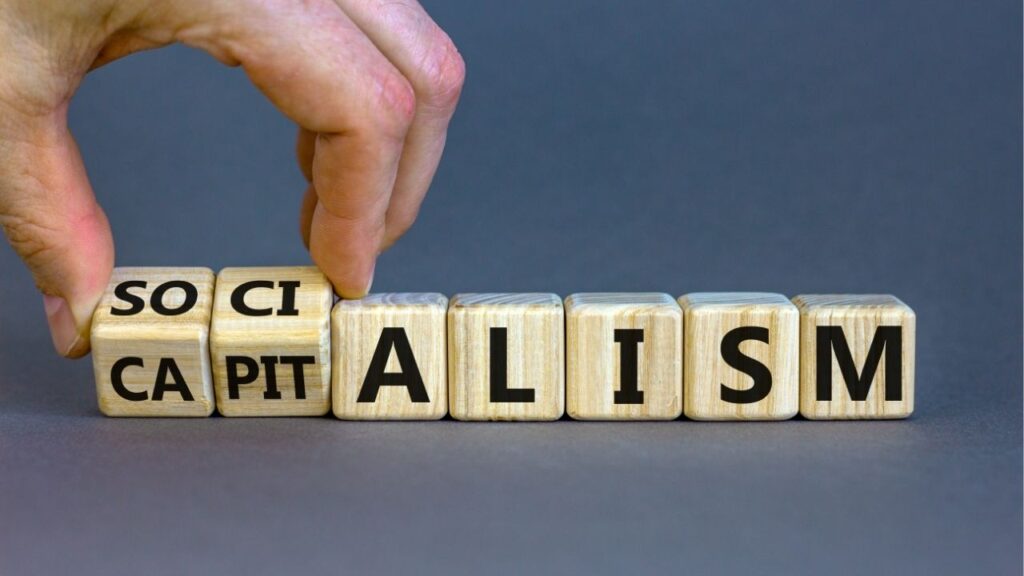 Asset id: 1869359083 Capitalism or socialism. Hand turns cubes and changes word 'capitalism' to 'socialism'. Beautiful white background, copy space. Business and capitalism or socialism concept.