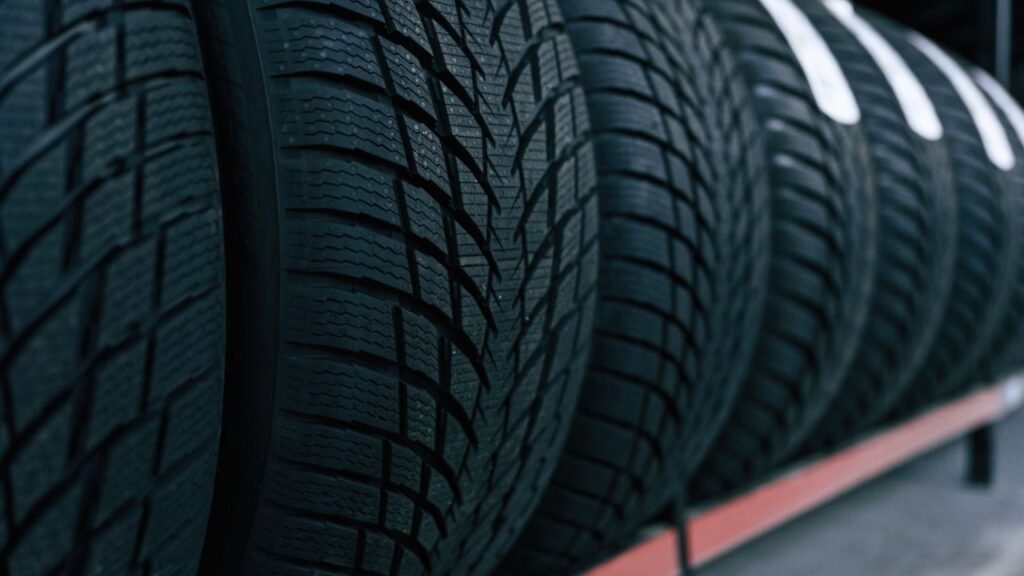 Asset id: 2511509547 Particle close up view. New tires are placed on the storage rack in the car workshop.