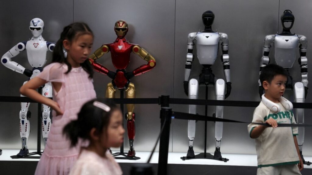 Children stand near Unitree's humanoid robots on display at a Unitree store in Beijing, China August 10, 2026. (Reuters File)