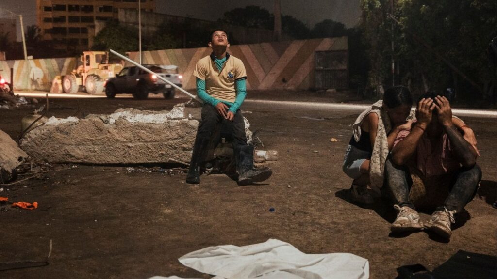Deivi Delfín leans against rubble to grieve after the bodies of missing family members were recovered after twin earthquakes in Caraballeda, Venezuela, July 19, 2026. A pair of brothers who lost their mother and other family members after twin earthquakes in Venezuela in June, on Monday, Aug. 10, 2026, when a 7.4 magnitude quake hit not far from Cali, Colombia, they found themselves once again at the center of a disaster. (Adriana Loureiro Fernandez/The New York Times)