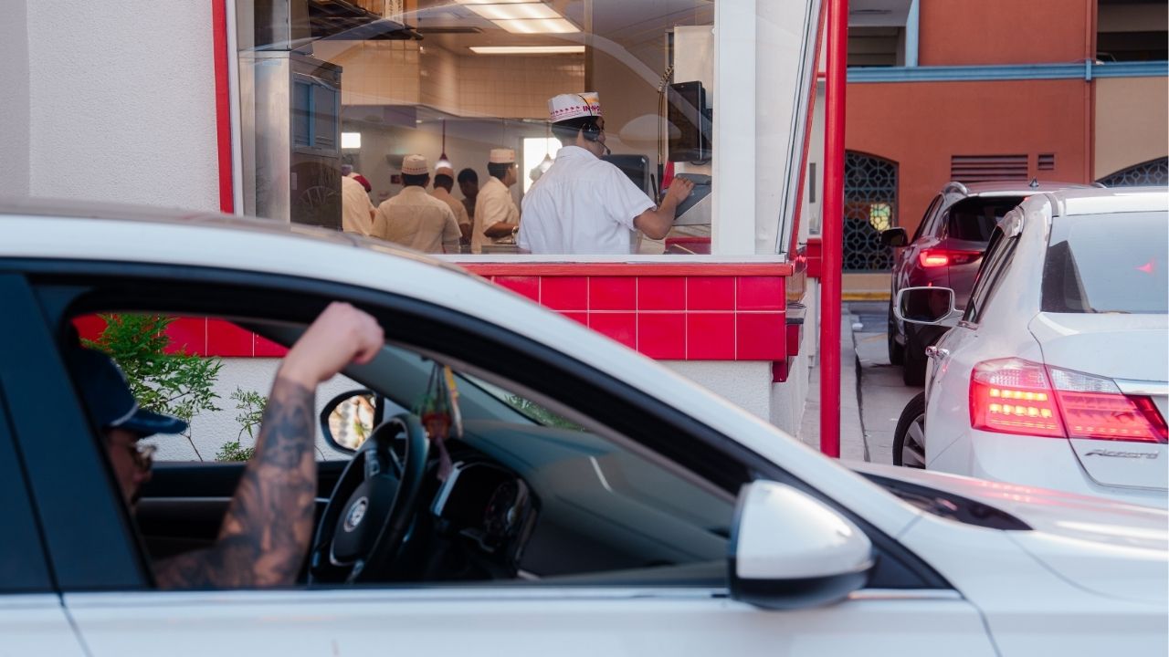 People wait in line at In-N-Out near the Los Angeles International Airport in Los Angeles, on July 21, 2026. The state gave rise to fast-food culture decades ago, but some cities are spurning drive-throughs because of the environmental and aesthetic impacts. (Gabriela Bhaskar/ The New York Times)