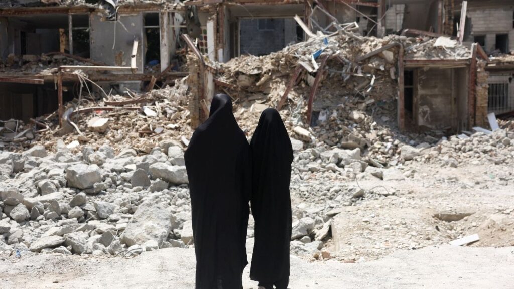 Iranian women look at a building, which was damaged in a U.S. and Israeli strike in March, in Tehran, Iran, August 22, 2026. Majid Asgaripour/WANA (West Asia News Agency) via REUTERS