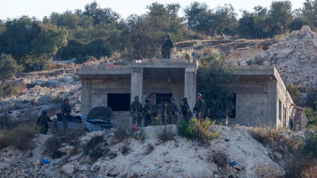 Israeli military forces stand by a building, following an Israeli military airstrike, in Jenin, in the Israeli-occupied West Bank, August 28, 2026. REUTERS/Mohammed Torokman