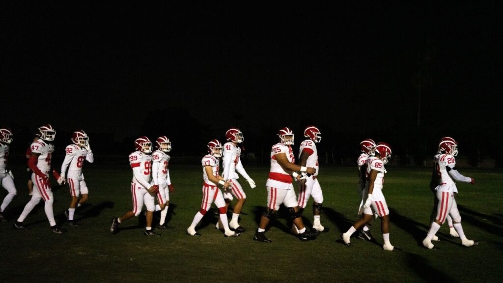 Mater Dei High School’s football team returns to the field for the 2nd half at the hosting St. John Bosco High School’s field, where an overflow crowd of 6,000 was watching the arch-rival’s clash, in Bellflower, Calif., Oct. 1, 2021. Many families are engaged in tense debates after a new study found a high percentage of NFL players had developed degenerative brain disease. (Gabriella Angotti-Jones/The New York Times)