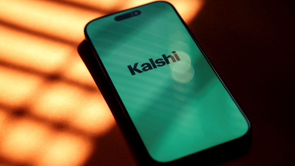 Image of the word "Kalshi" in black lettering on a cellphone screen against a light green background