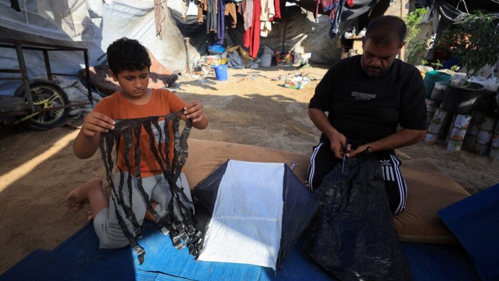 Palestinians make a kite at a tent camp sheltering displaced people in Gaza City, August 25, 2026. REUTERS/Dawoud Abu Alkas
