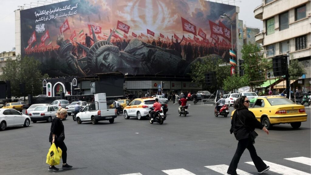 People walk past an anti-U.S. billboard on a street in Tehran, Iran, August 3, 2026. (Majid Asgaripour/WANA (West Asia News Agency) via Reuters)