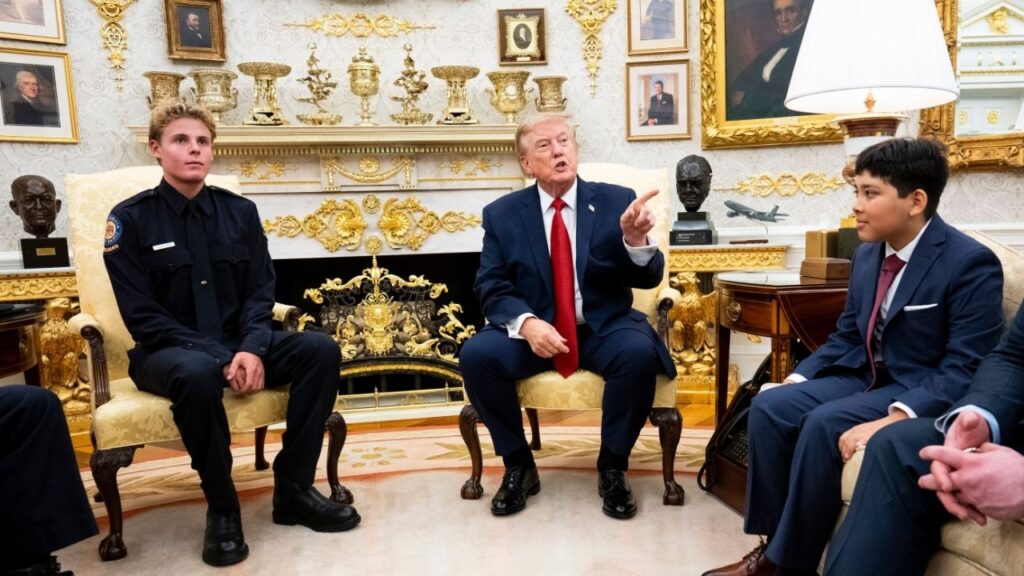 President Donald Trump meets with Ryder Williams, left, and Nathaniel Rai, right, in the Oval Office of the White House in Washington, on Monday, Aug. 17, 2026. Williams, a lifeguard, rescued Rai, 10, amid pounding surf at Seabright Beach in Santa Cruz, Calif., in July. (Doug Mills/The New York Times)