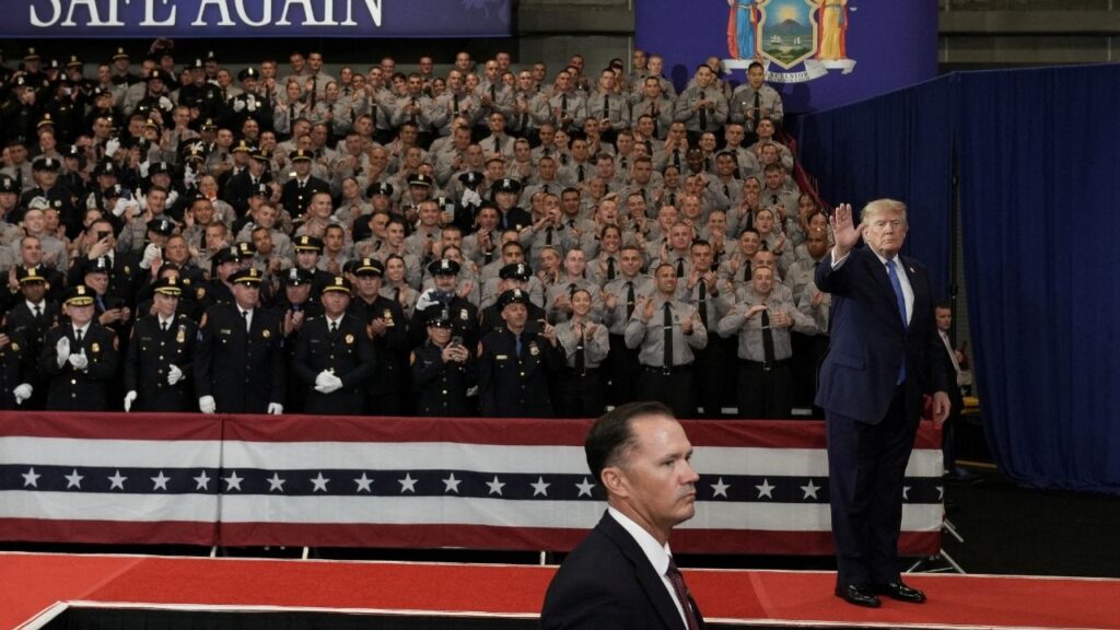 President Donald Trump waves during an event at David S. Mack Center for Training and Intelligence in Garden City, New York, U.S., August 14, 2026. REUTERS/Ken Cedeno
