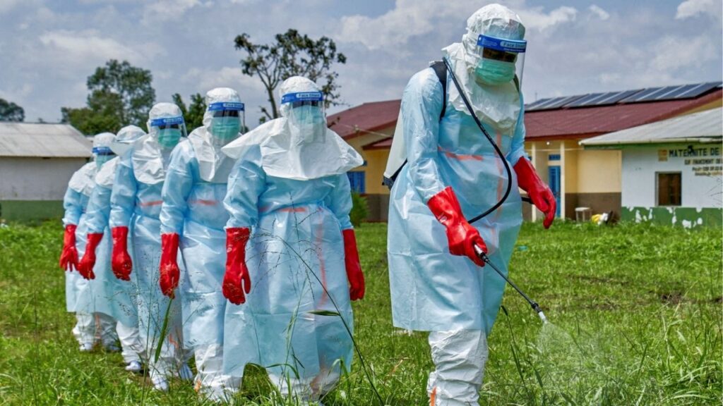 Red Cross workers walk in a formation as they disinfect Rwampara general hospital before handling the body of a person who died of Ebola, as aid agencies intensify efforts to contain a new Ebola outbreak involving the Bundibugyo strain, in Rwampara outside Bunia, Ituri province, Democratic Republic of Congo, May 21, 2026. (Reuters File)