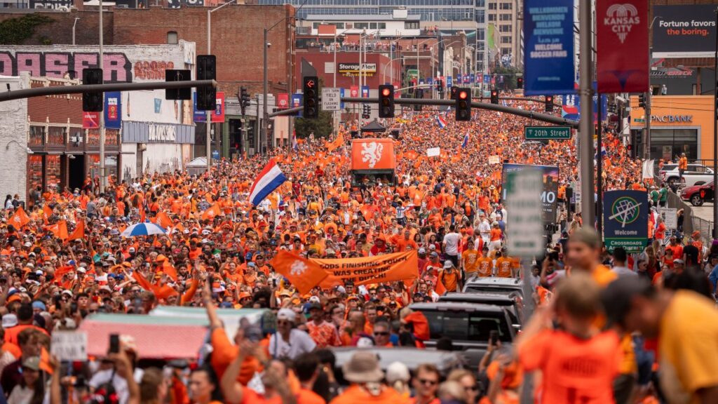 Image of thousands of orange-clad soccer fans crowding a street in Kansas City, Missouri