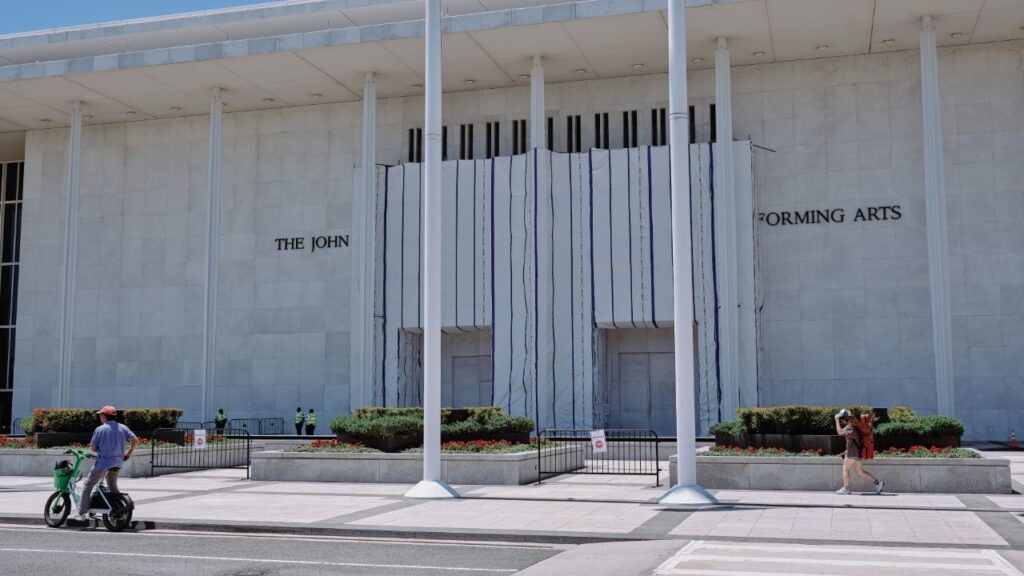 The John F. Kennedy Center for the Performing Arts, with the area where President Donald Trump’s name was added, and then ordered removed, covered by material hanging from scaffolding, in Washington, June 24, 2026. The Kennedy Center board voted on Aug. 13, 2026 to move forward with Trump’s plan to shutter the building for renovations. (Jared Soares/The New York Times)