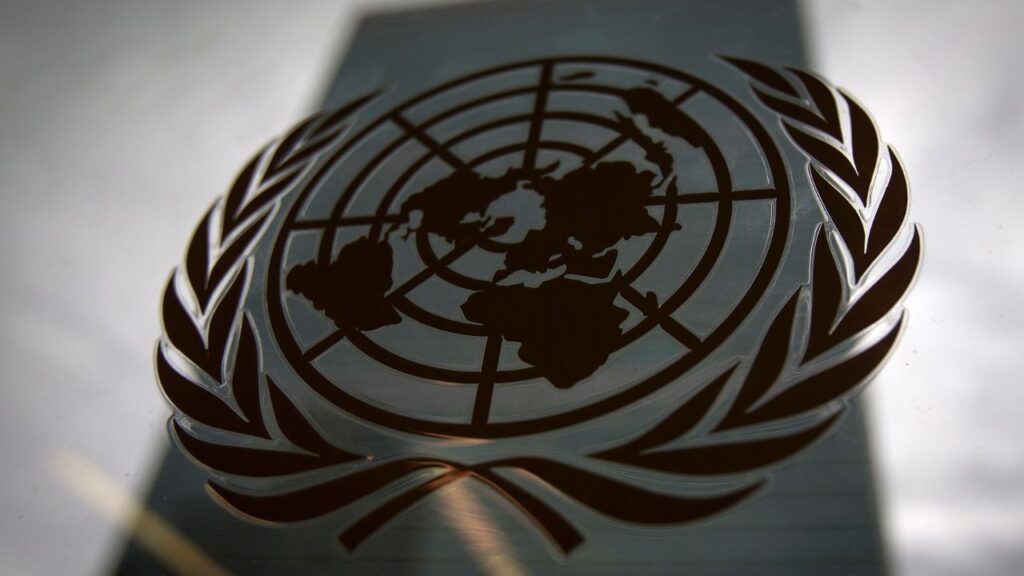 The United Nations headquarters building is pictured though a window with the UN logo in the foreground in the Manhattan borough of New York August 15, 2014. (Reuters/Carlo Allegri)