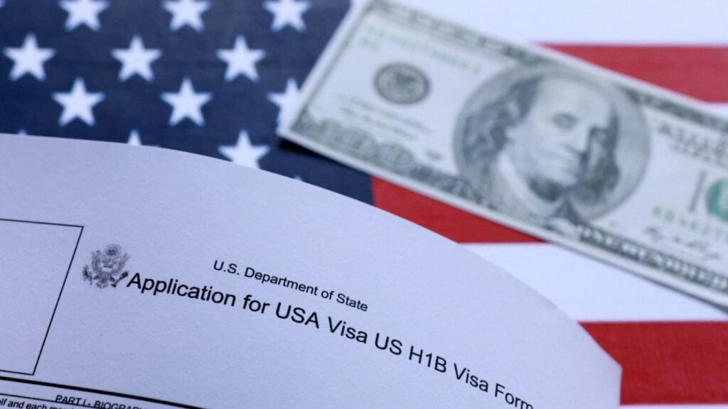 U.S. flag, mock passport, 100 dollar banknote and H-1B visa application form are seen in this illustration taken September 26, 2025. REUTERS/Dado Ruvic/Illustration