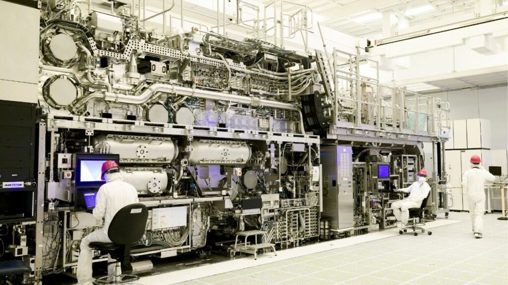 Workers are seen in front of a "High NA EUV" lithography system at an Intel facility in Hillsboro, Oregon, U.S. in this handout image obtained by Reuters on April 19, 2024. Intel said on April 18 that it has become the first company to assemble one of the machines made by Dutch computer chip equipment supplier ASML, which are expected to lead to new generations of smaller, faster computer chips. (Reuters File)