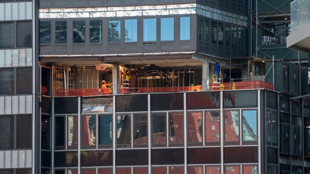 Workers on the floor above bent columns at 235 East 42nd Street, the former Pfizer headquarters that is being converted into housing, in New York on July 8, 2026. The Midtown Manhattan high rise that became dangerously unstable had more columns that were missing reinforcements than was previously known, according to documents obtained by The New York Times, and reviewed by independent engineers. (Hiroko Masuike/The New York Times)