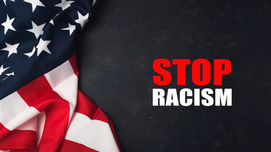 American flag and the words "Stop Racism" in red and white on a dark background