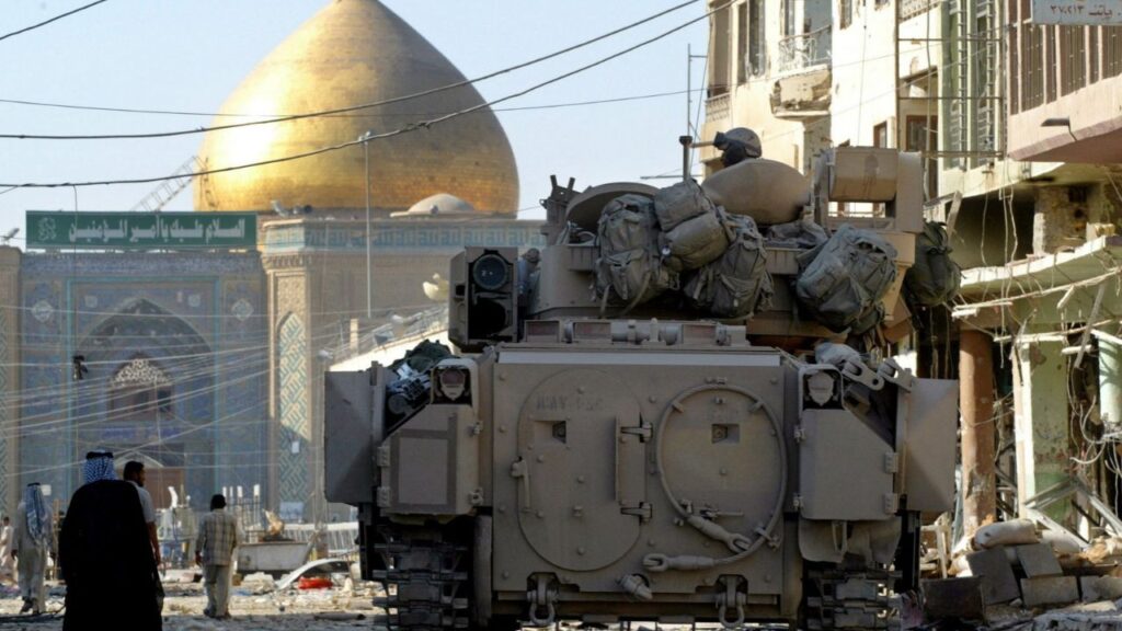 A U.S. Army Bradley armoured vehicle of the 1st Cavalry division guards a street leading from the cemetery to Imam Ali shrine, in Najaf, Iraq, August 27, 2004. REUTERS/Chris Helgren/File Photo