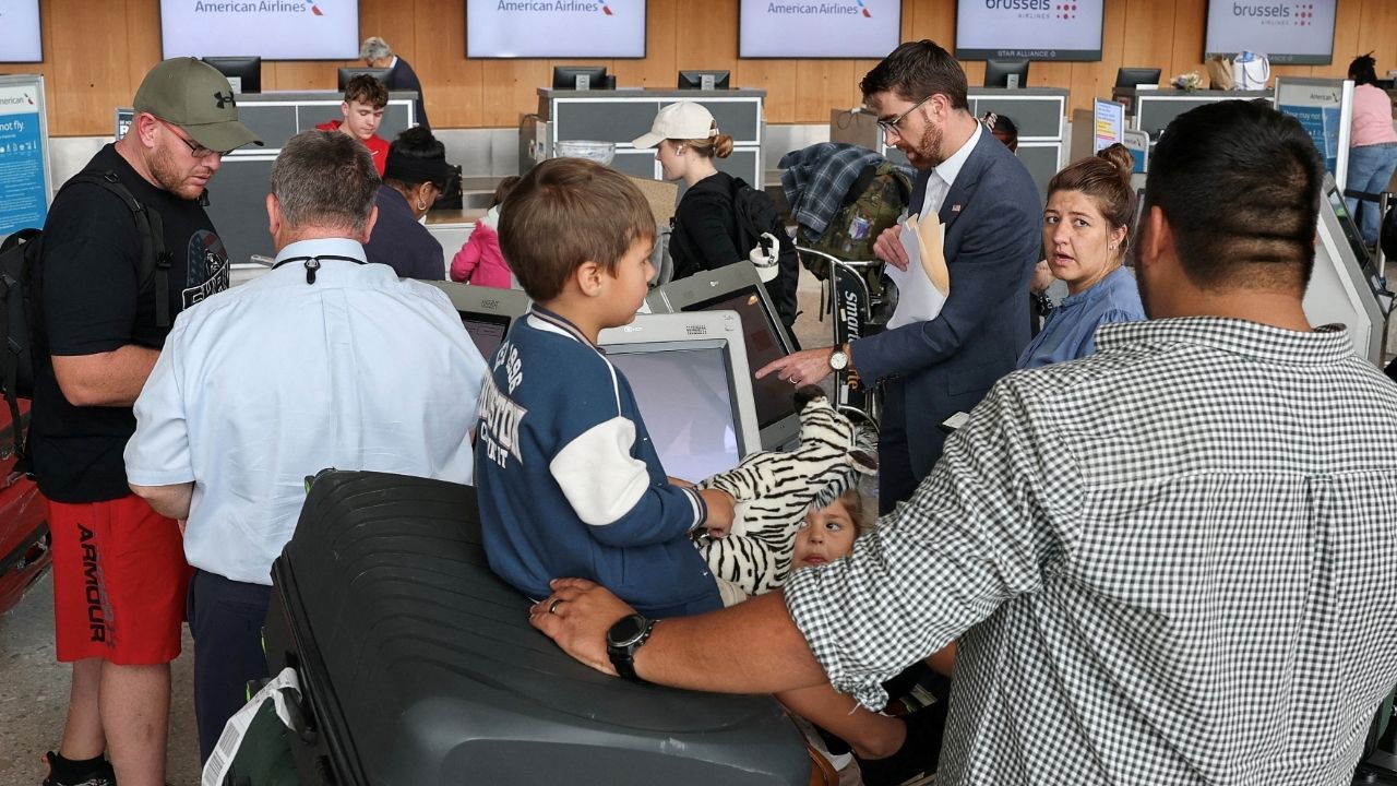 A U.S. State Department official helps people from the first group of white South Africans granted refugee status for being deemed victims of racial discrimination under U.S. President Trump's Refugee plan, check in for a connecting flight, at Dulles International Airport, in Dulles, Virginia, U.S., May 12, 2025. (Reuters File)