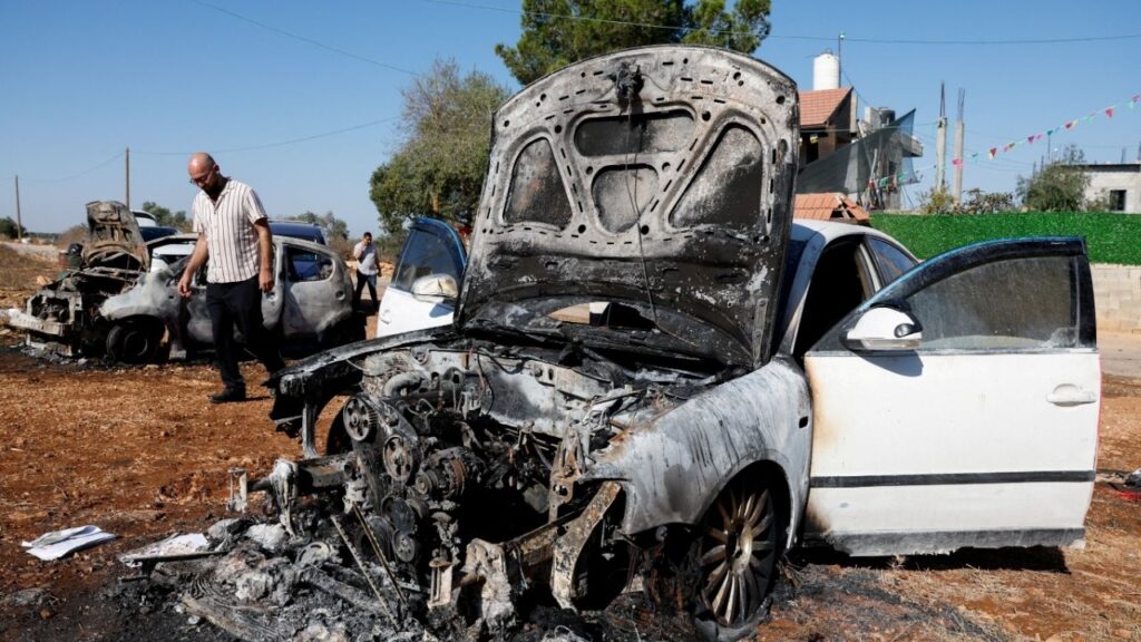 A man walks past destroyed cars, which Palestinians say were burned by Israeli settlers last night, in Beita, near Nablus, in the Israeli-occupied West Bank, September 2, 2026. REUTERS/Mohammed Torokman