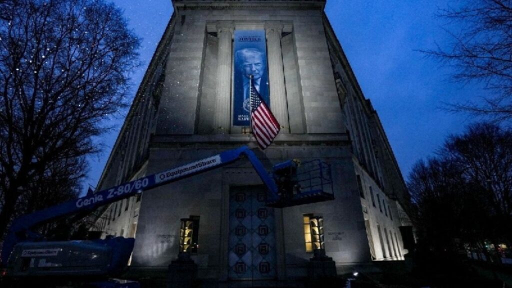 A new banner depicting U.S. President Donald Trump is put up on the Department of Justice building in Washington, D.C., U.S., February 20, 2026. REUTERS/Ken Cedeno