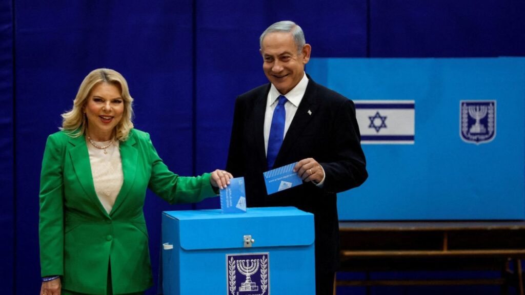 Benjamin Netanyahu stands next to his wife Sara as they cast their ballots on the day of Israel's general election in a polling station in Jerusalem November 1, 2022. (Reuters File)