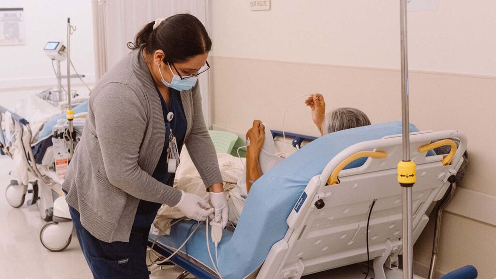 A patient receives assistance in a hallway at Martin Luther King Jr. Community Hospital in Los Angeles, Oct. 20, 2025. Employer health costs are expected to spike in 2027 as a new survey anticipates an average increase of 11 percent unless benefits are cut, the highest rate in decades. (Morgan Lieberman/The New York Times)