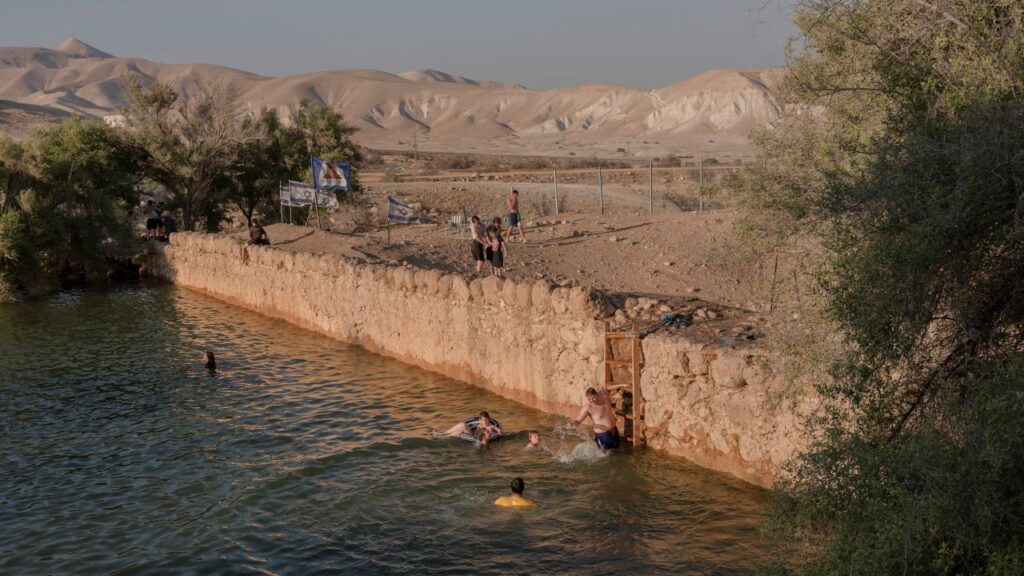 Image of men swimming in a small reservoir formed by a stone wall