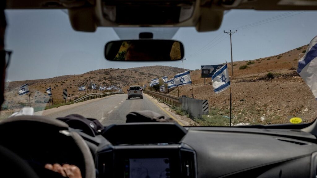 Israeli flags line the roadside next to Palestinian farms in the Jordan Valley, in the Israeli-occupied West Bank, June 23, 2026. A growing number of former Israeli generals, intelligence officials and prime ministers are accusing settlers in the West Bank of committing ethnic cleansing with government support. “Once a society behaves this way,” one said, “that society is doomed.” (Ivor Prickett/The New York Times)