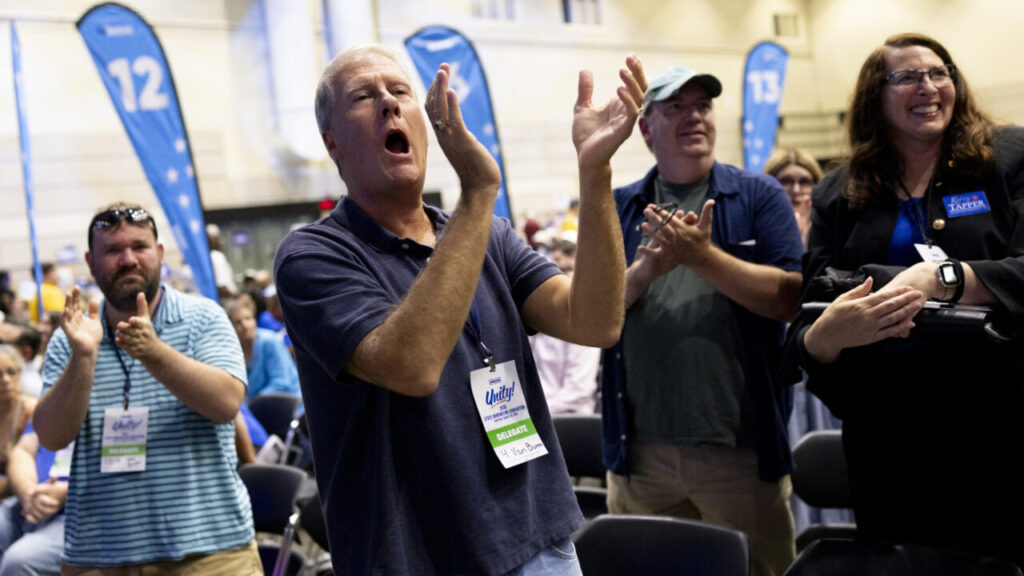 Image of conventioneers standing, yelling, and clapping