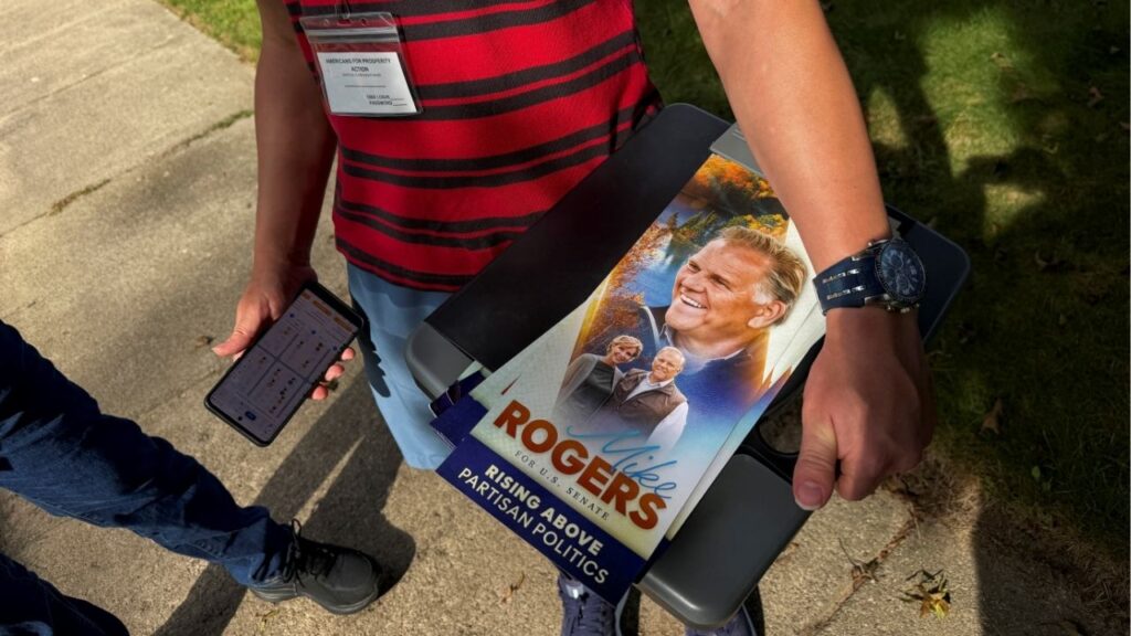 A canvasser for Americans for Prosperity Action, a conservative super PAC, holds a leaflet for Republican U.S. Senate candidate Mike Rogers while door knocking in Livonia, Michigan, U.S., September 14, 2026. Picture taken with a mobile phone. Reuters/Nathan Layne