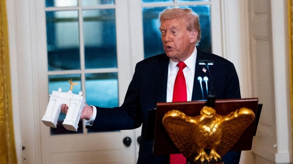 President Donald Trump holds a model of his proposed “Independence Arch” during a fundraising dinner in the East Room of the White House in Washington, Oct, 16, 2025. President Trump said his planned 250-foot triumphal arch in Washington would be built to host “large numbers of drones,” snipers and ammunition, as the administration appeared prepared to justify another construction project by citing national security. (Doug Mills/The New York Times)