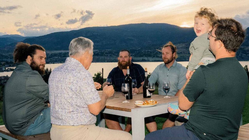 Tony Holler, back to camera, with his four sons and grandson at Poplar Grove, their family-operated winery in Penticton, British Columbia, Canada, on Sept. 10, 2026. Even as the winery represents a rare winner in the trade war, it is being hampered by tariffs and uncertainty. (Alana Paterson/The New York Times)