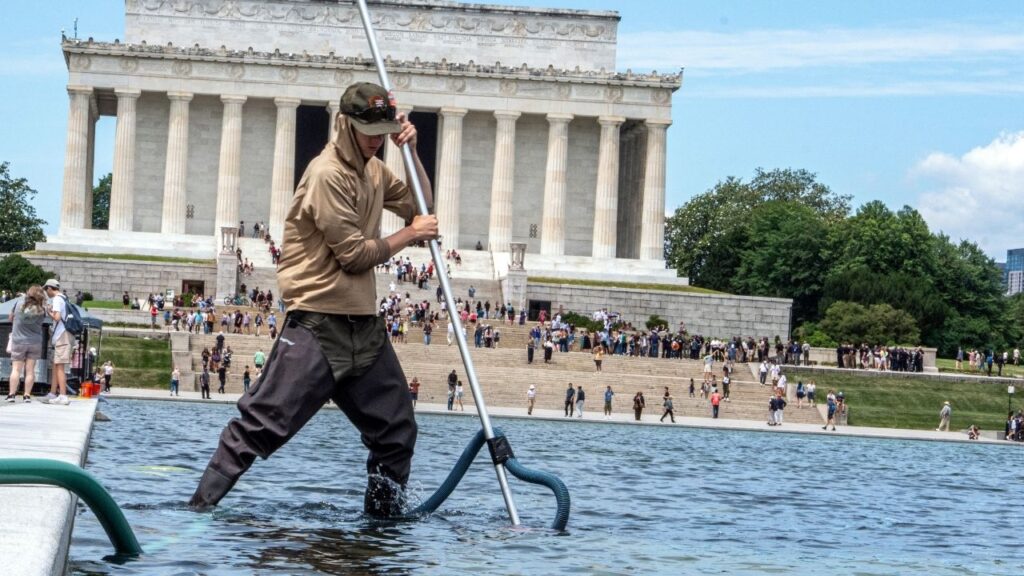 Workers attempt to clean algae bloom from the renovated Reflecting Pool in Washington on June 19, 2026. The tab for the various construction projects that President Donald Trump has launched come with a potential cost of as much as $1 billion, much of it at taxpayer expense. (Alex Kent/The New York Times)