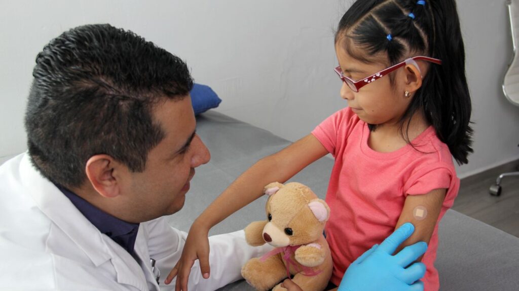 Image of doctor comforting a young girl after a vaccination