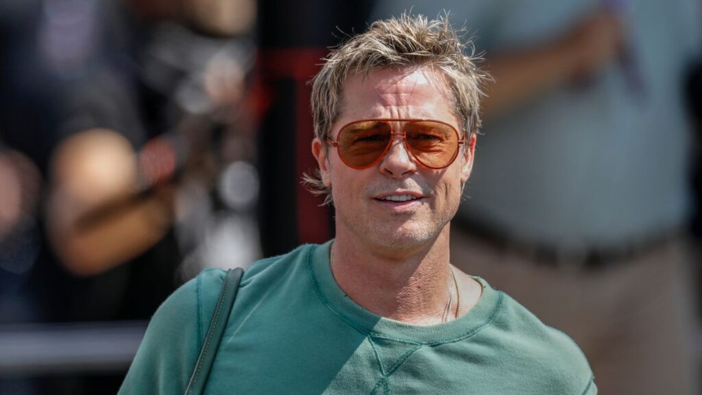 Image of Brad Pitt in a green t-shirt, wearing sunglasses and walking toward the camera