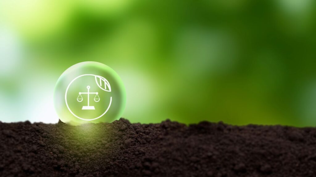 Composite image of a green sphere with the scales of justice and brown soil, symbolizing environmental law