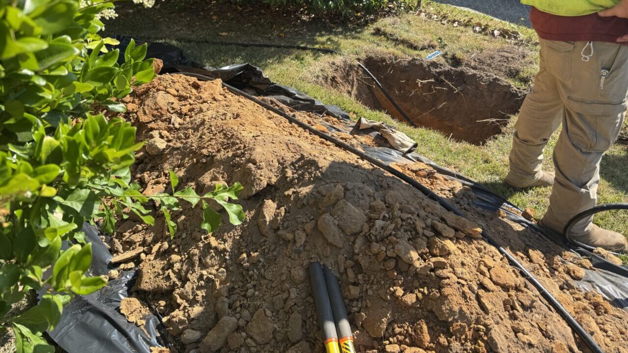 Image of a hole in the ground where a news residential gas line is being installed