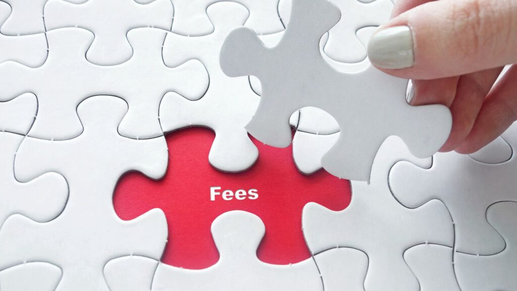 Close up of girl's hand placing the last jigsaw puzzle piece with word Fees