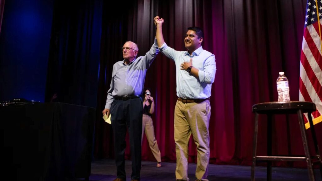 Image of Bernie Sanders and Randy Villegas with arms raised
