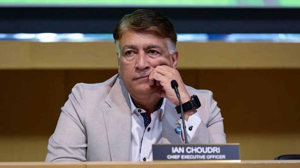 Image of Ian Choudri sitting on a dais with his hand to his cheek