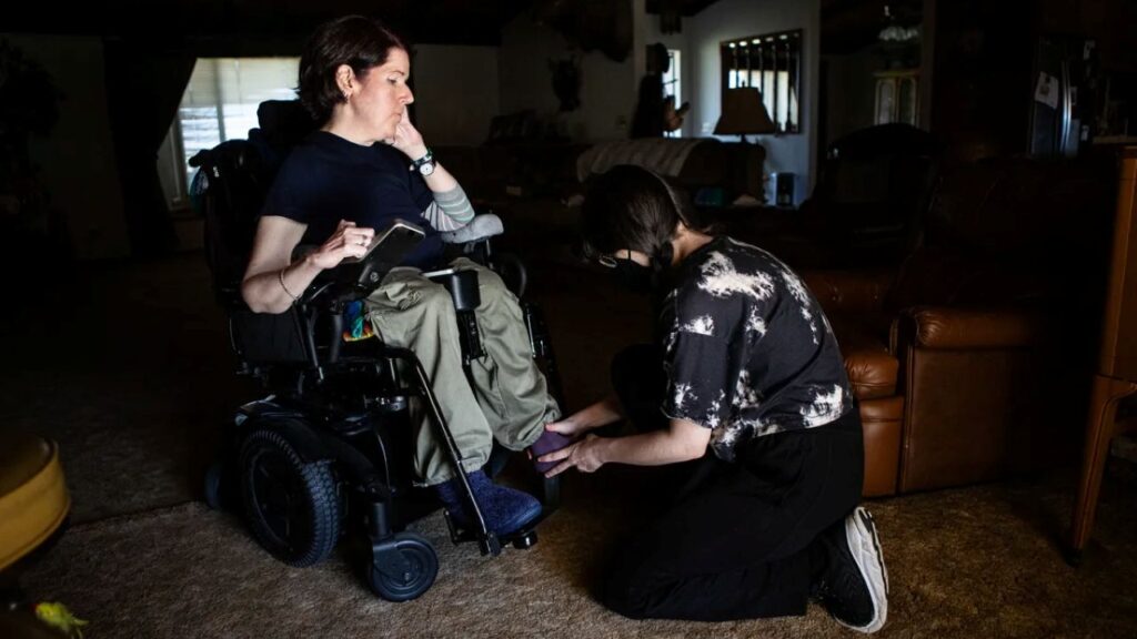 Image of a medical aide attending to a woman in a wheelchair